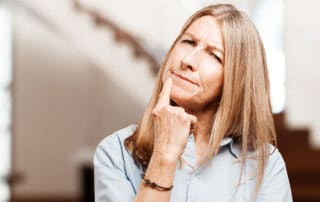 Senhora de meia idade, aposentada do serviço público com expressão de dúvida.