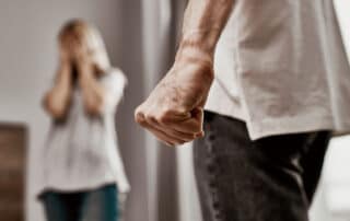 Ilustrando a capa da matéria “Policiais podem afastar agressores de vítimas de violência doméstica” exibimos uma fotografia colorida onde no primeiro plano, é possível ver um homem com o punho fechado (cerrado), em nítida expressão de violência. No plano de fundo e desfocado, uma mulher com as mãos tampando seu rosto, presume-se que assustada.