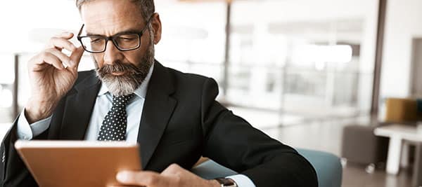 Ilustrando a matéria Como escolher uma pós-graduação em Direito vemos a fotografia de um homem de meia idade, aparentando ser um advogado experiente.