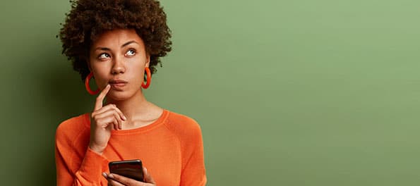 Para ilustrar a matéria “Correção do saldo do PIS/PASEP. Como funciona?”, vemos a foto de uma mulher negra pensando sobre uma questão.