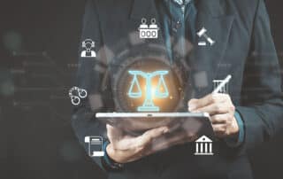 Como capa da matéria “O que são Lawtechs e Legaltechs”, vemos um advogado com um tablet e elementos relacionados ao Direito flutuando ao redor da tela.