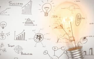 Como capa da matéria “Empreendedorismo na Advocacia: Novos caminhos para advogados”, vemos uma luz acesa com desenhos de gráficos ao fundo.