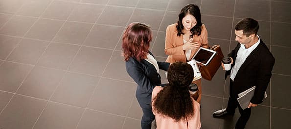Grupo de advogados em pé discutindo algo. 4 advogados em pé discutindo algo.