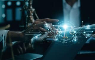 Como capa da matéria “Construindo Conexões: Networking na Faculdade de Direito”, vemos um advogado usando um laptop com símbolos do direito em holograma por cima.