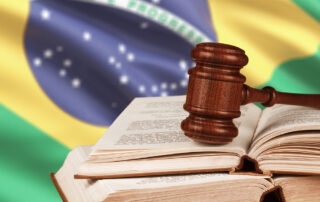 Como capa da matéria “As 12 leis mais bizarras do Brasil”, vemos um martelo de juiz sobre livros com a bandeira do Brasil ao fundo.