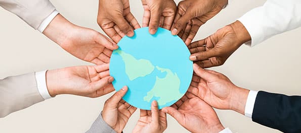 Várias mãos segurando um recorte do globo terrestre. Várias mãos segurando um recorte do globo terrestre.